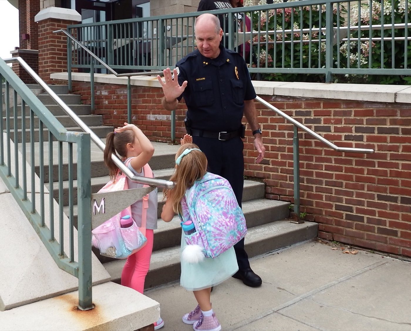 Police Chief Paul Rickard greeting children outside their school